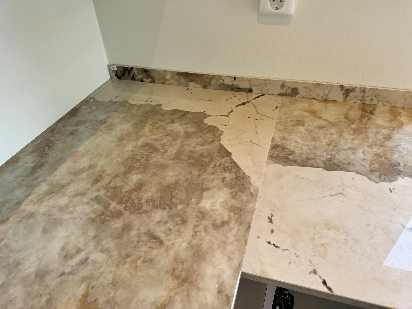 Närbild av polerad Dekton Khalo bänkskiva med gråbeige ådring och låg stänkkant i kök i Malmö.