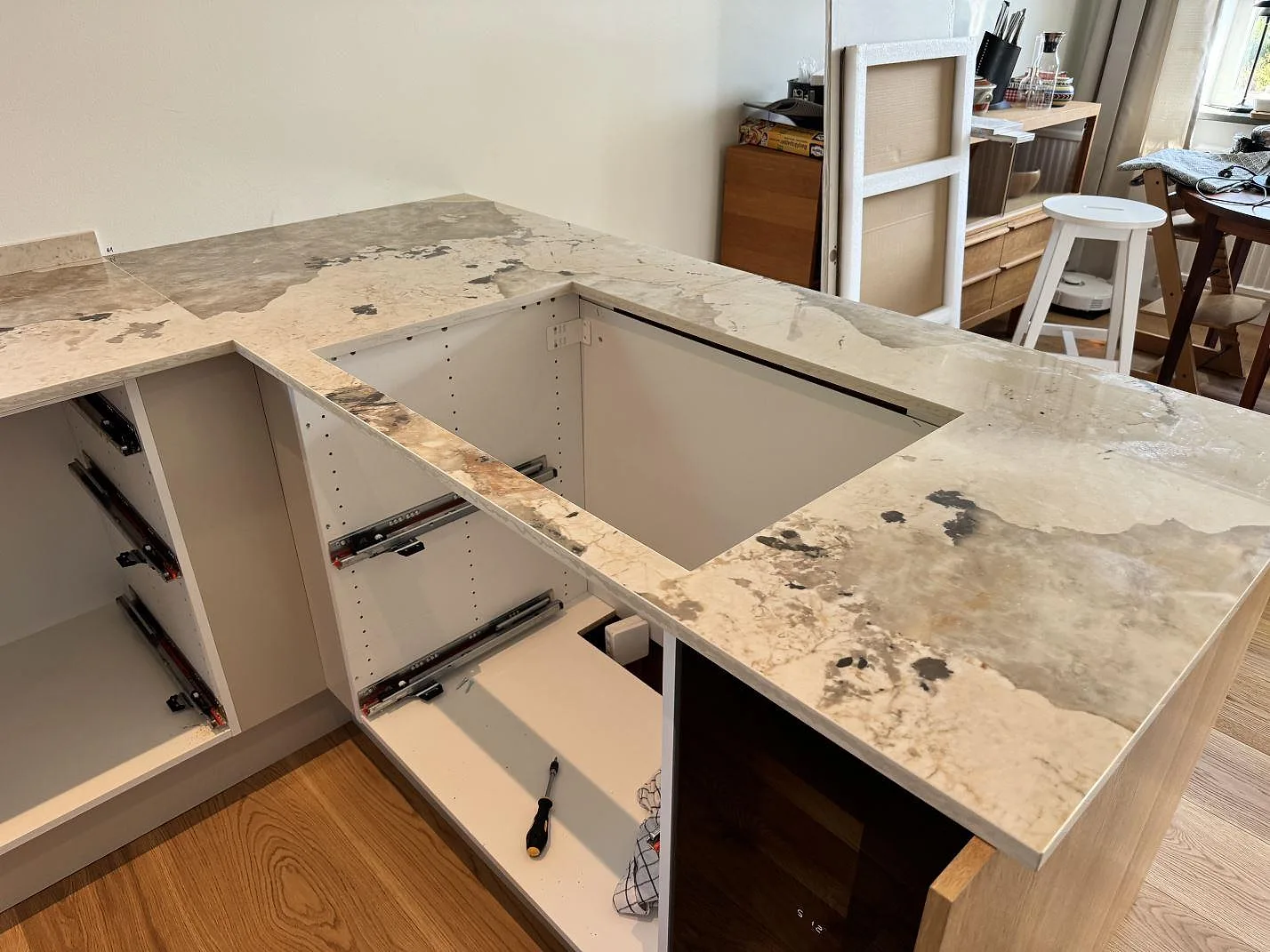 Polerad köksbänkskiva i Dekton Khalo med stort rektangulärt urtag i halvön och öppna stommar i Malmö.