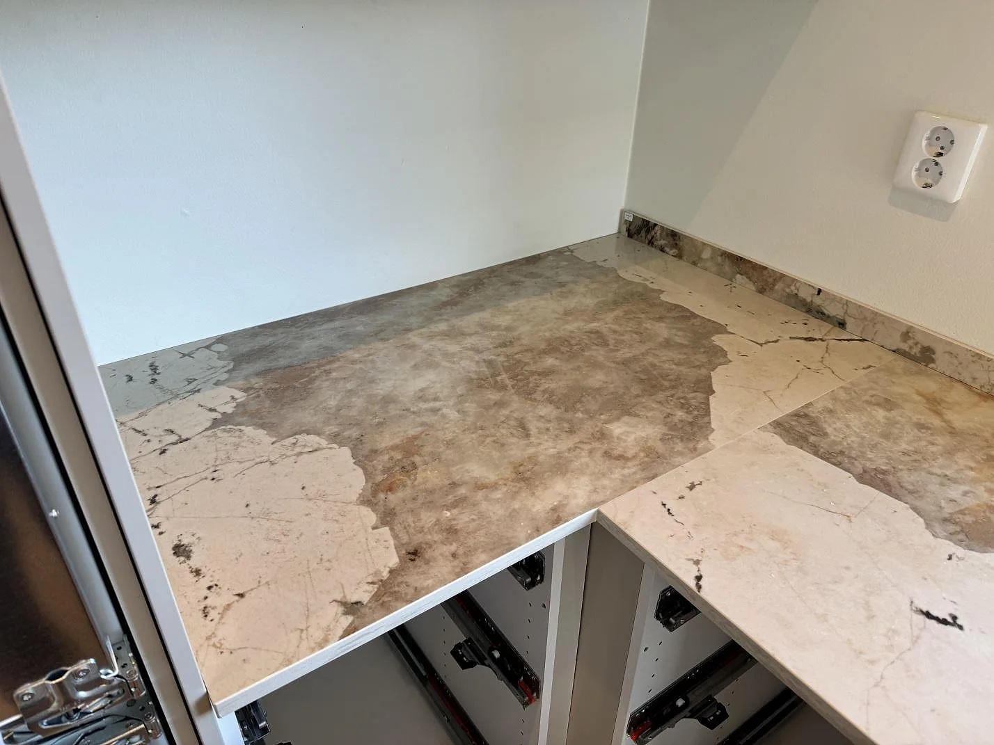 Hörndel av polerad köksbänkskiva i Dekton Khalo med låg stänkkant och öppna köksstommar i Malmö.