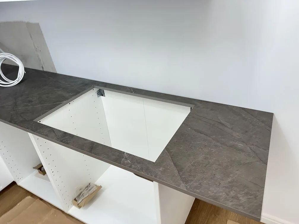 Grå Dekton Kira köksbänkskiva med utskuret urtag för underlimmad diskho över öppna köksstommar i Immeln.