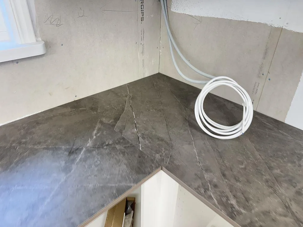Hörnparti av grå Dekton Kira köksbänkskiva med matt yta och naturlig ådring i ett kök i Immeln.