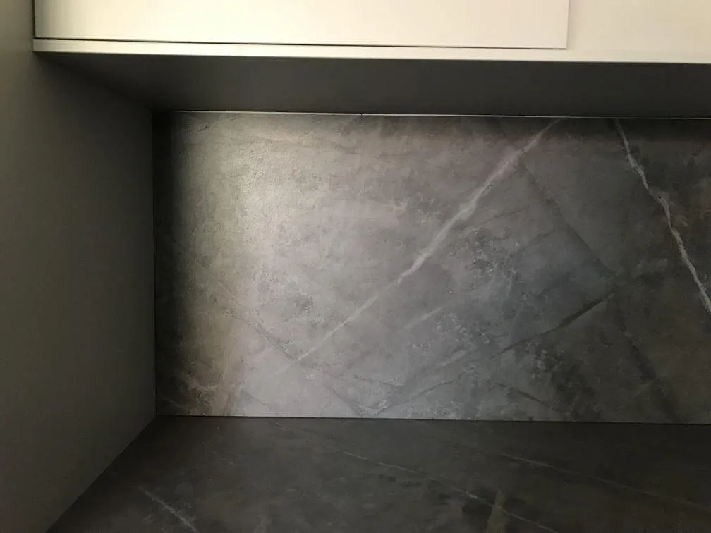 Matt Dekton Kira köksbänkskiva med uppvikt stänkskydd och diskret grå ådring i ett kök i Malmö.