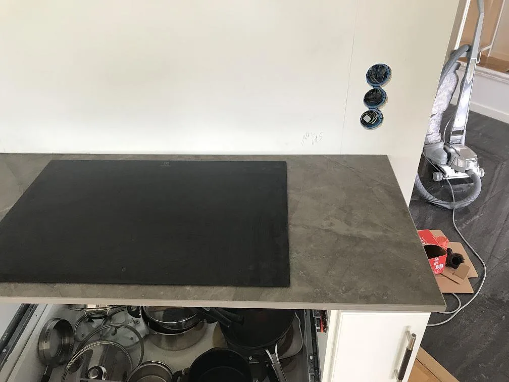 Köksbänkskiva i antracitgrå Dekton Kira, matt, med induktionshäll och plats för diskho i ett kök i Torslanda.