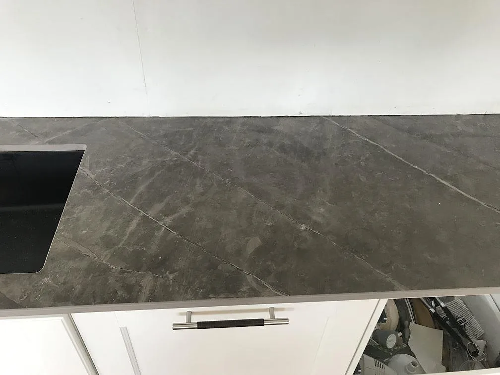 Närbild ovanifrån på matt Dekton Kira köksbänkskiva med diskhourtag och ljus ådring i ett kök i Torslanda.
