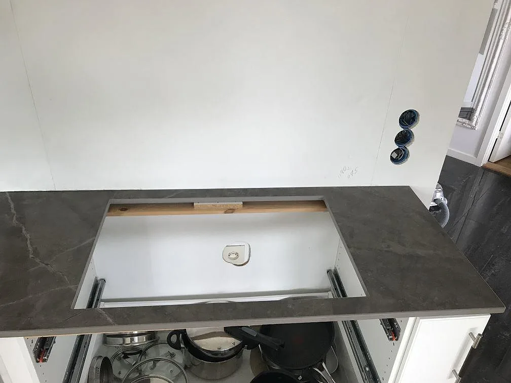 Svart induktionshäll inlagd i en matt Dekton Kira köksbänkskiva i antracitgrått i ett kök i Torslanda.
