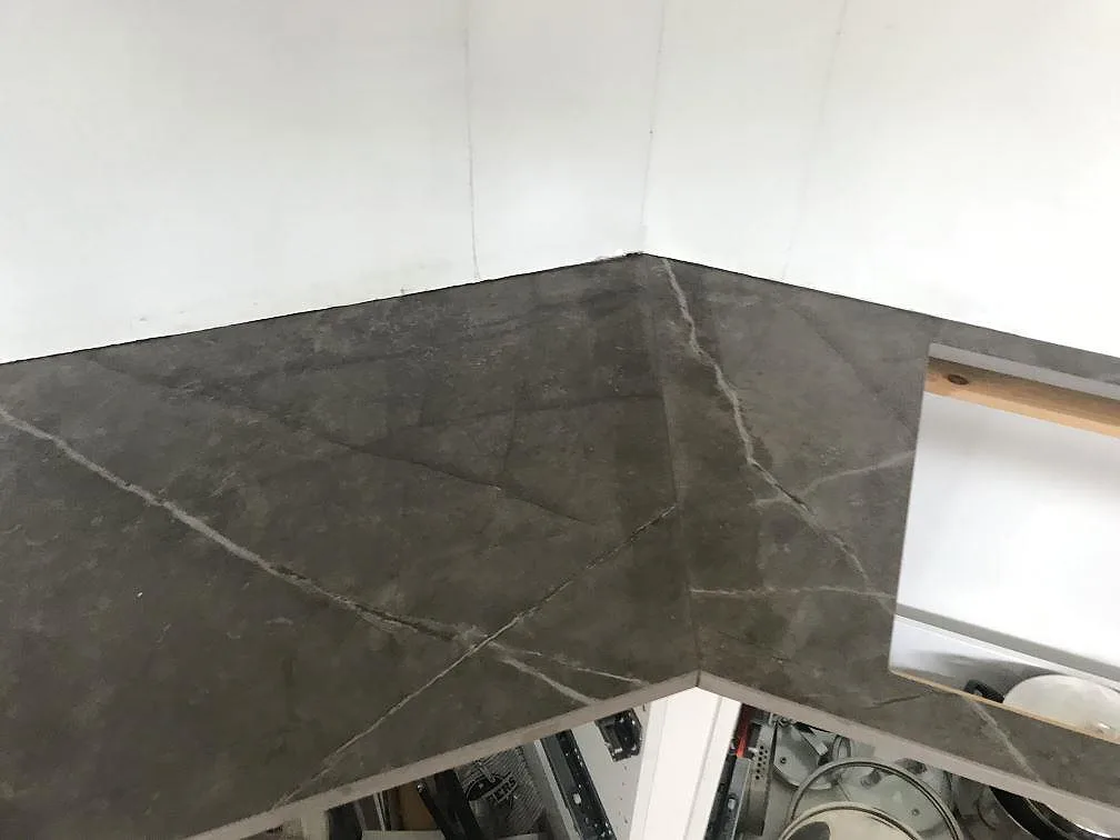 Hörnlösning med matt Dekton Kira köksbänkskiva i antracitgrått längs väggen i ett kök i Torslanda.