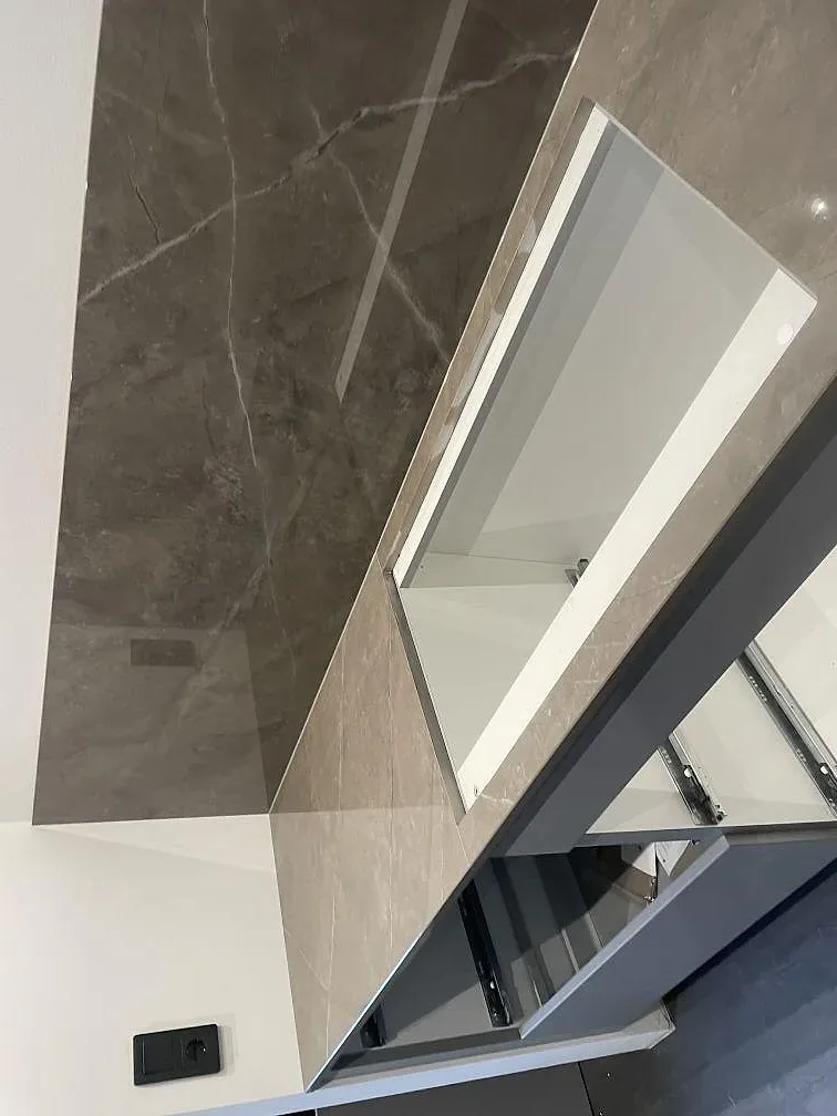 Närbild på urtag och stänkskydd i polerad Dekton Korso keramik med vita stommar i Häljarp.