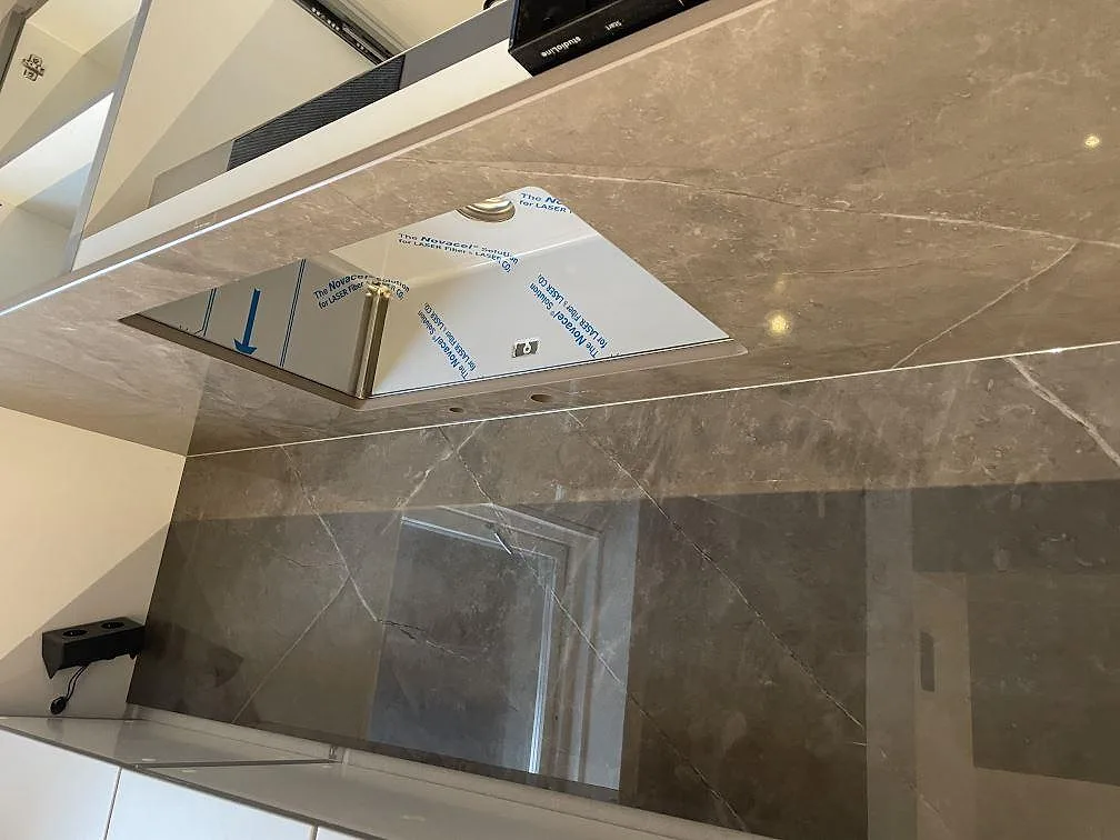 Närbild på polerad Dekton Korso bänkskiva med urtag och matchande stänkskydd i ett kök i Häljarp.