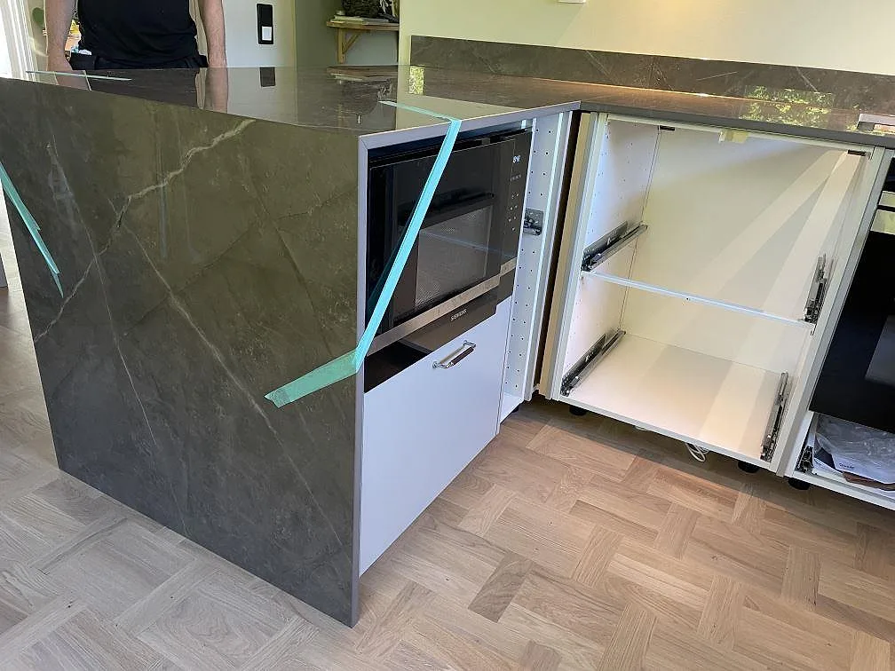 Polerad Dekton Korso som bänkskiva och front på halvön, monterad i ett kök med ljusa stommar i Kullavik.