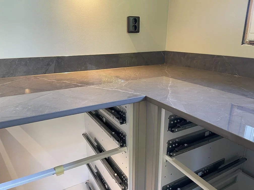 Närbild av 20 mm köksbänkskiva i Dekton Korso med polerad yta och uppvikt stänkkant i Kullavik.