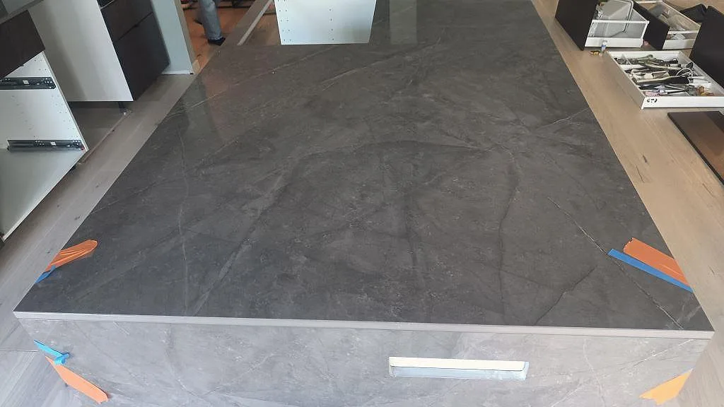Närbild på polerad Dekton Korso över köksön med tejpade monteringsskarvar i Staffanstorp.