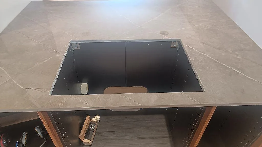 Diskholäge i polerad Dekton Korso med mörk keramikyta och valnötsstommar under montering i Trollhättan.