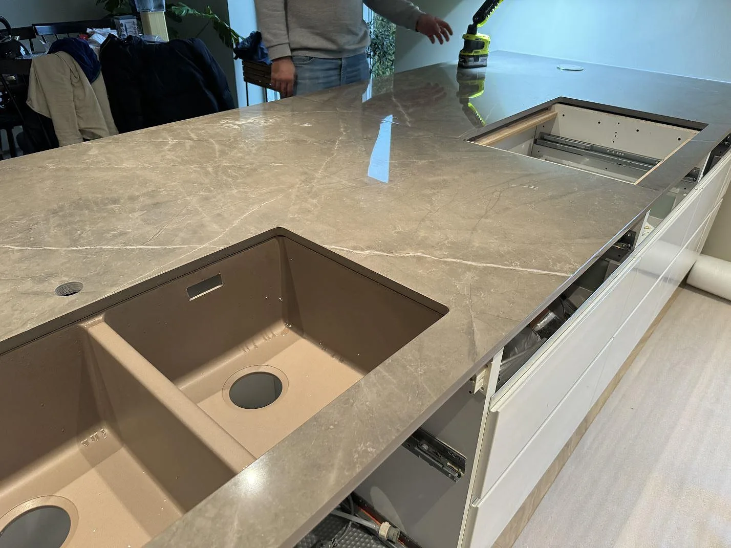 Närbild på dubbel underlimmad rostfri diskho i polerad Dekton Korso på köksö i Tygelsjö.