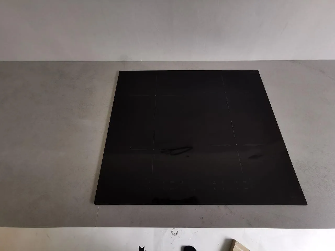 Övermonterad induktionshäll på en bänkskiva i Dekton Kovik, matt grå keramikyta, kök i Malmö.