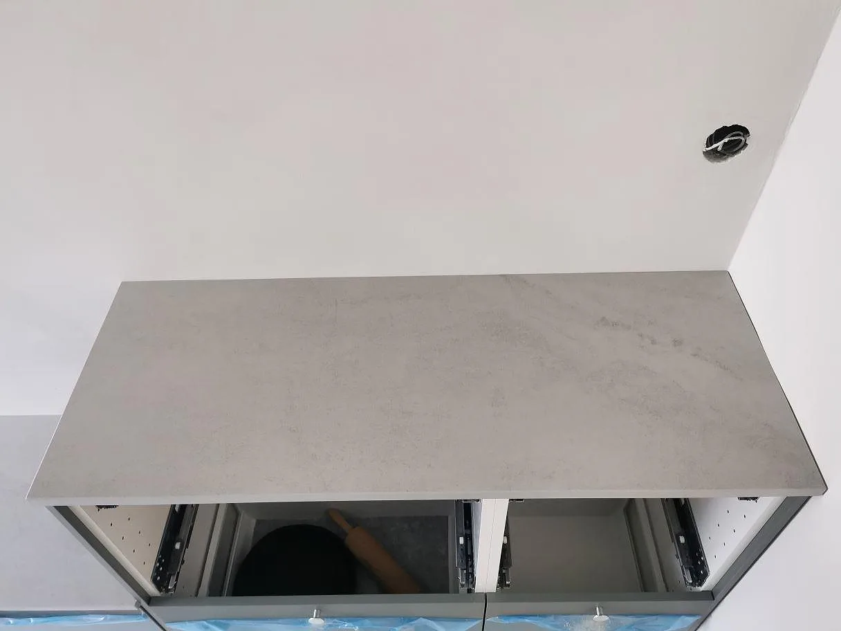 Bänkskiva i Dekton Kovik ovanför öppna lådstommar under montering i ett kök i Malmö.
