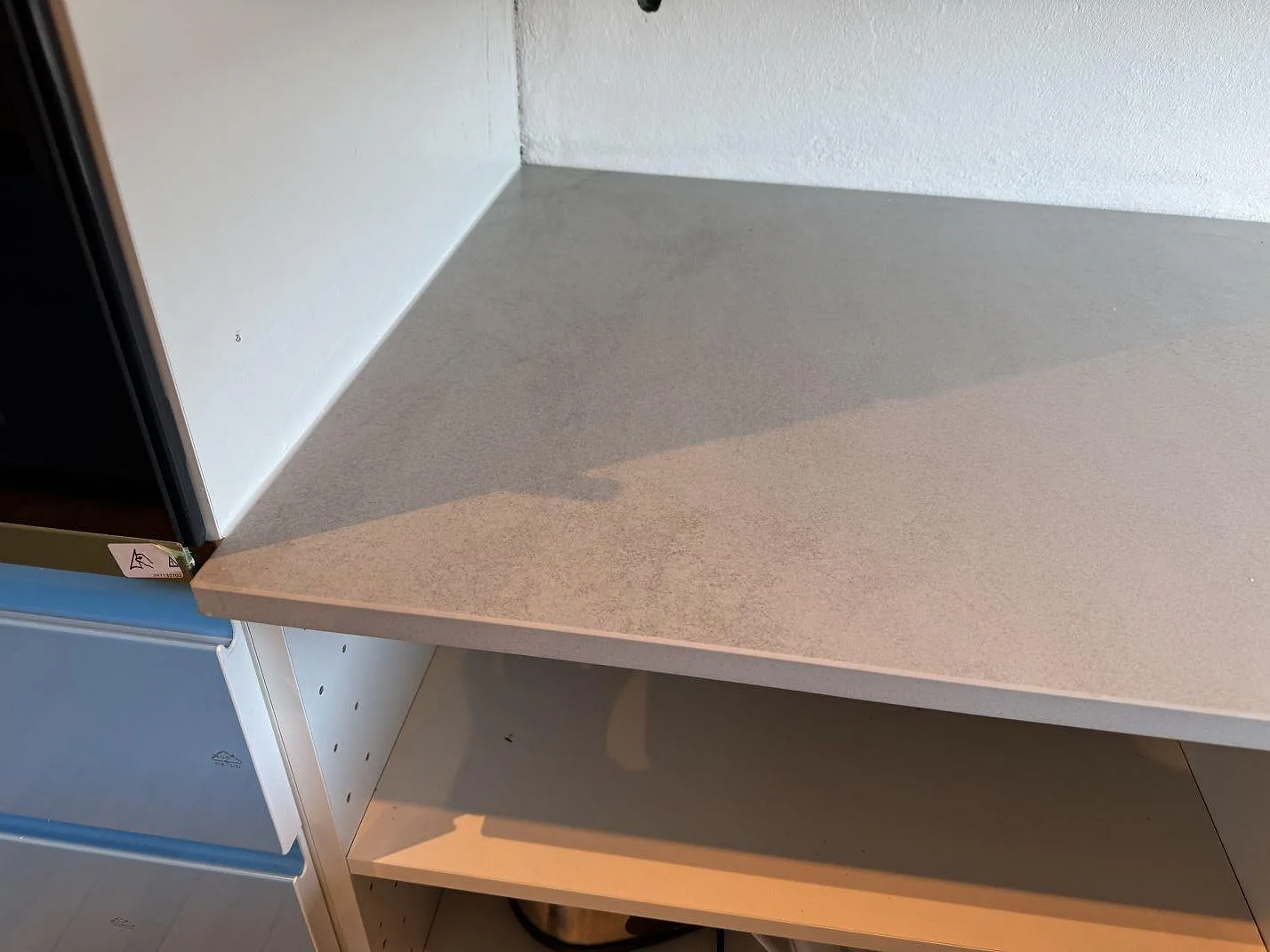 Detalj av matt Dekton Kovik-bänkskiva med gråbeige stenstruktur och rak framkant i Rydebäck.