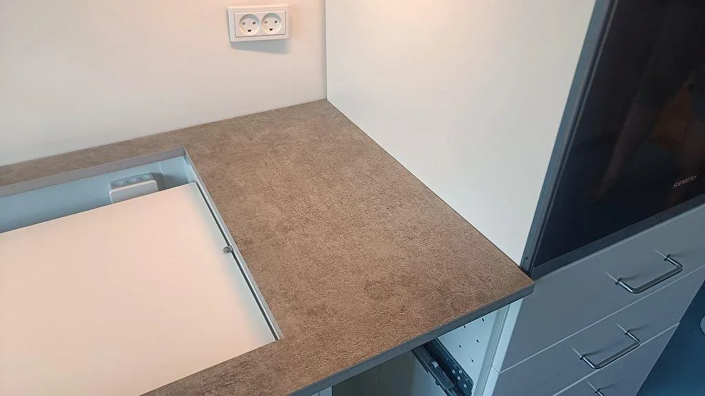 Detalj av matt Dekton Kreta köksbänkskiva med grå struktur, ugnssida och öppen stomme i Albertslund.