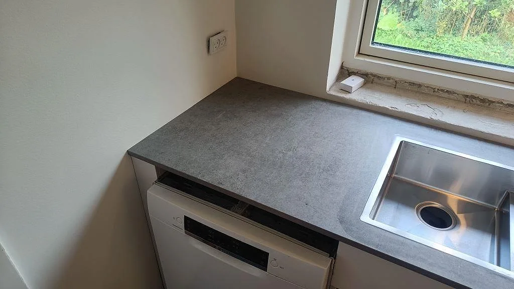 Matt köksbänkskiva i Dekton Kreta keramik vid rostfri diskho och diskmaskin under montering i Albertslund.