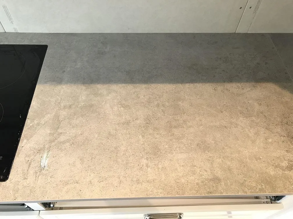 Honad Dekton Kreta köksbänkskiva i grått med infälld induktionshäll i ett kök i Karlskrona.