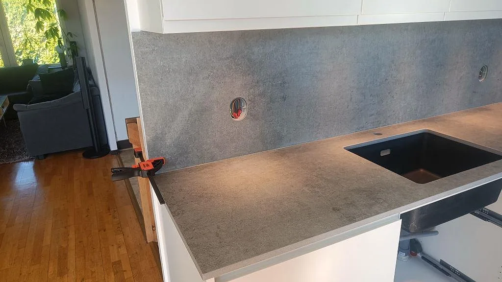 Matt Dekton Kreta som köksbänkskiva med underlimmad svart diskho och grå stänkskyddsskiva i ett kök i Malmö.