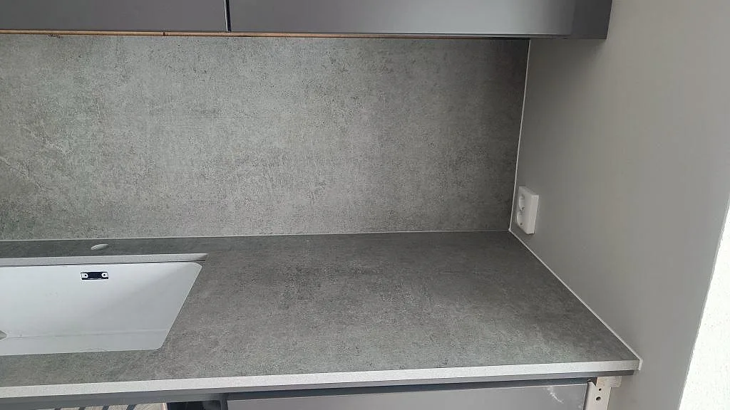Grå Dekton Kreta bänkskiva med underlimmad diskho och stänkskydd i samma sten i ett kök i Mullsjö.