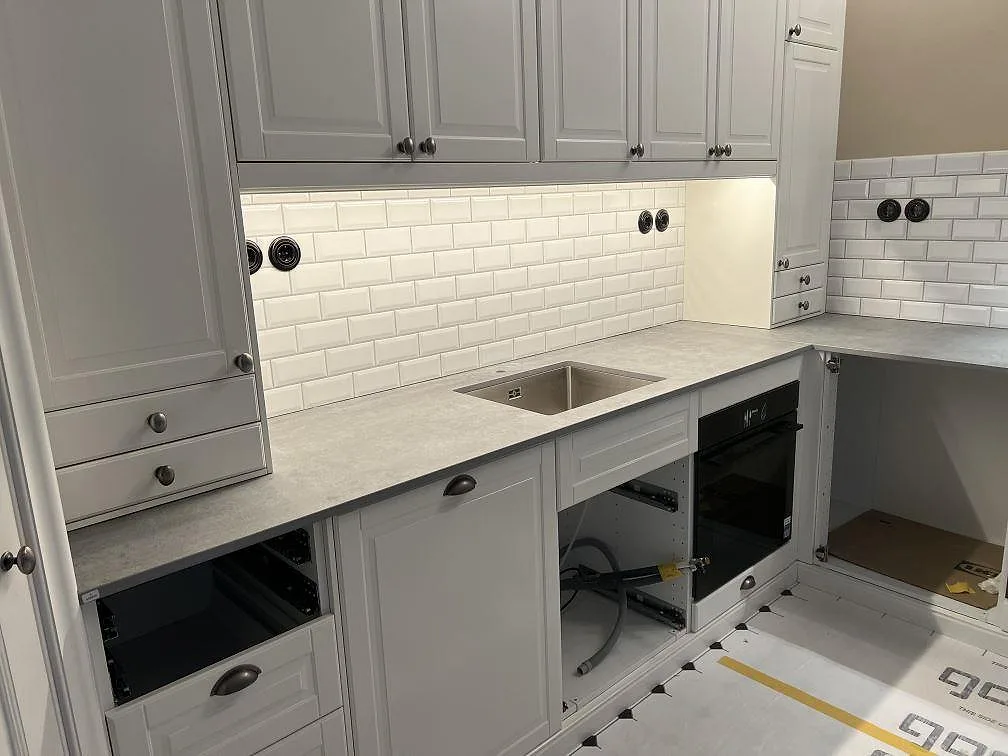 Matt Dekton Kreta köksbänkskiva med synlig diskho och kaklad vägg i ett kök i Stockholm.