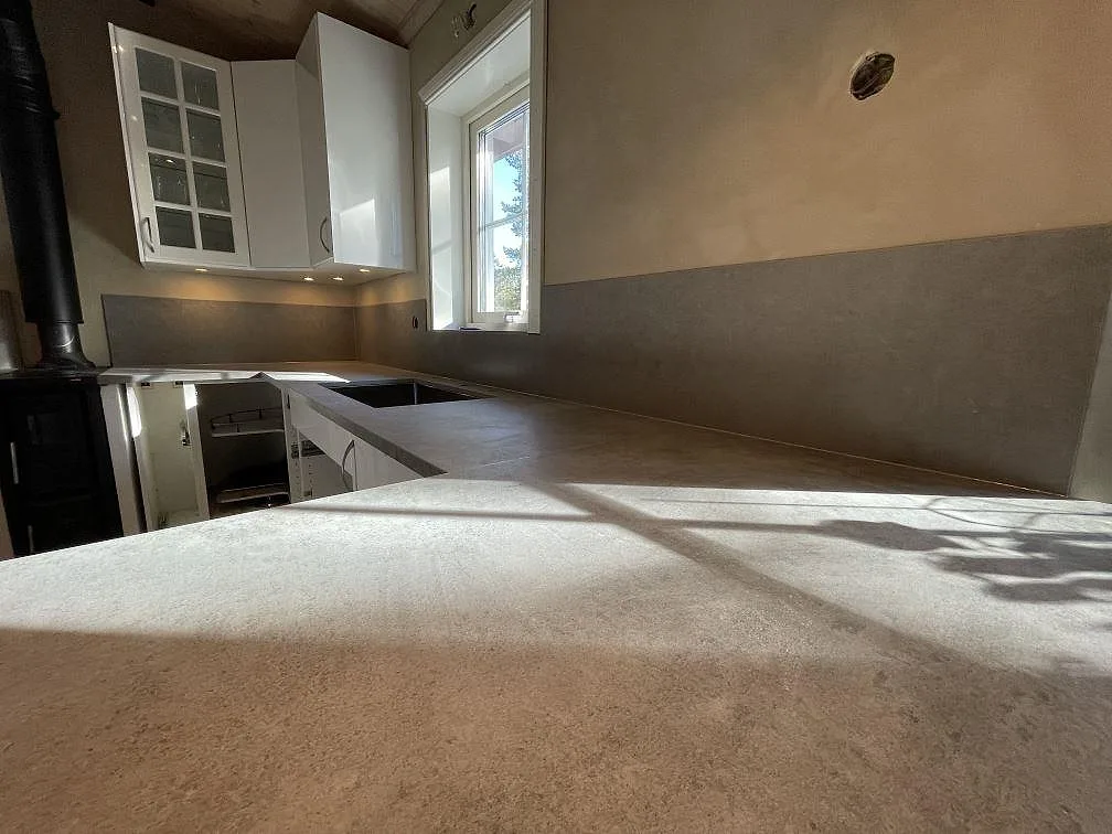 Närbild på matt Dekton Kreta som köksbänkskiva och stänkskydd, med grå betonglik yta i Vendelsö.