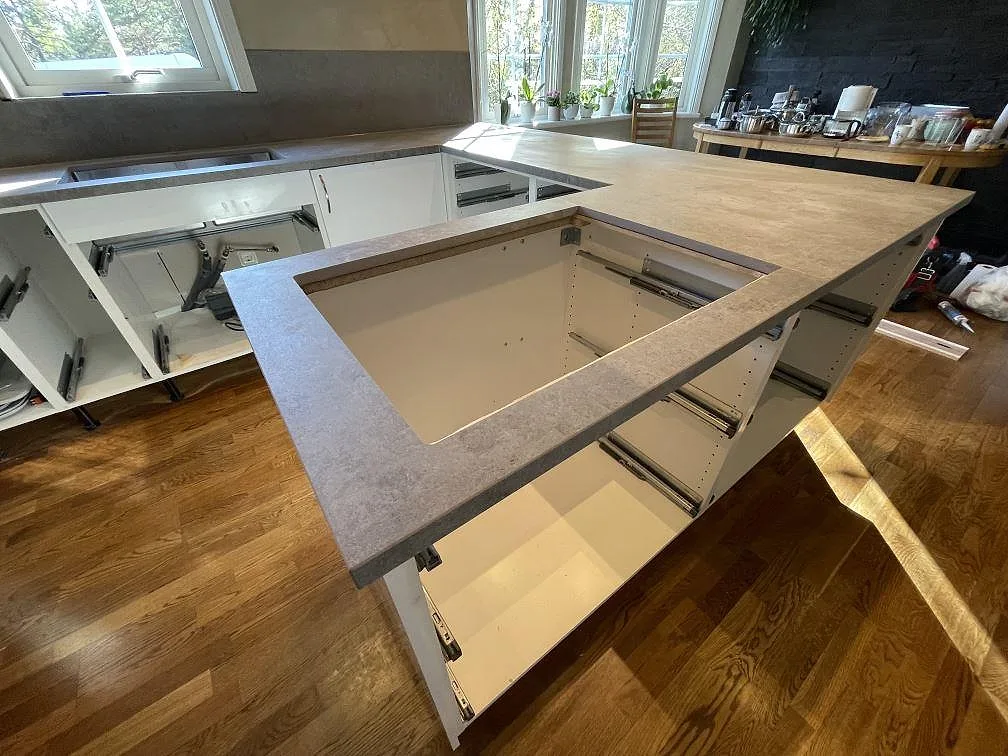 Detalj av framskjuten bänkdel i matt Dekton Kreta med stort urtag och raka kanter i köket i Vendelsö.