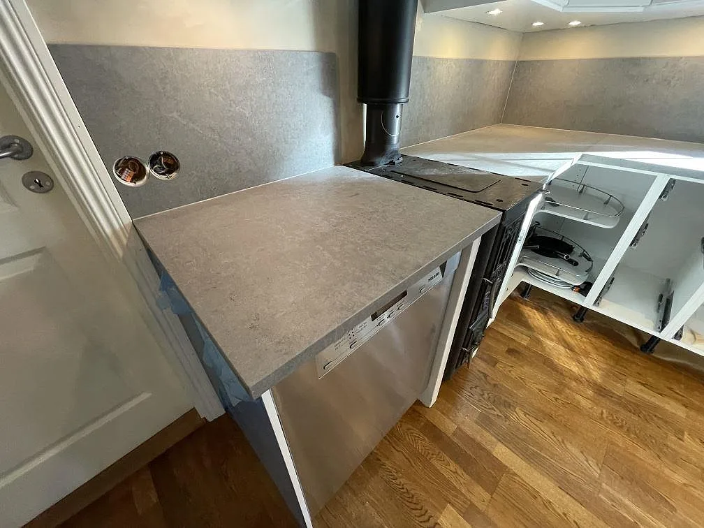 Matt Dekton Kreta monterad i hörnet vid köksstommar och stänkskydd, med grå yta och dagsljus i Vendelsö.