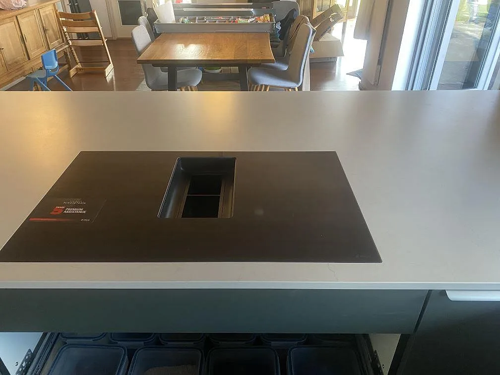 Närbild av köksö i matt Dekton Laguna Velvet med svart induktionshäll och ljusgrå keramisk yta i Hvidovre.