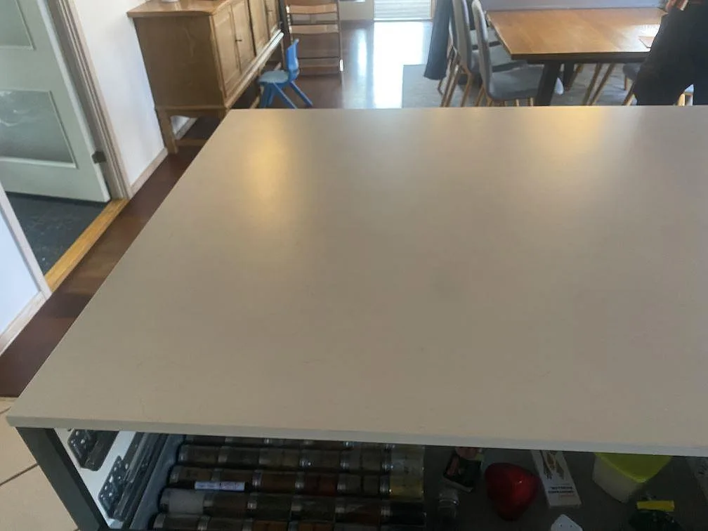 Stor köksö i ljusgrå matt Dekton Laguna Velvet med tunn kantprofil i ett kök under montering i Hvidovre.