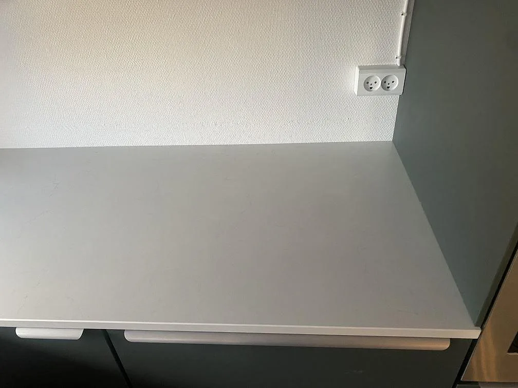Rak bänkskiva i matt Dekton Laguna Velvet på mörkgröna och vita köksstommar i Hvidovre.