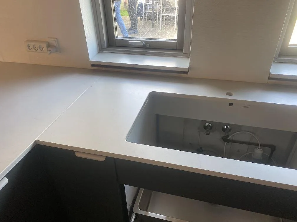 Matt Dekton Laguna Velvet vid fönster och diskzon, monterad som ljusgrå köksbänkskiva i Hvidovre.
