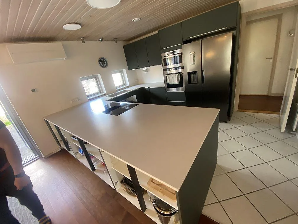 Köksbänkskiva i ljusgrå matt Dekton Laguna Velvet, keramik, på köksö och väggbänkar i ett öppet kök i Hvidovre.