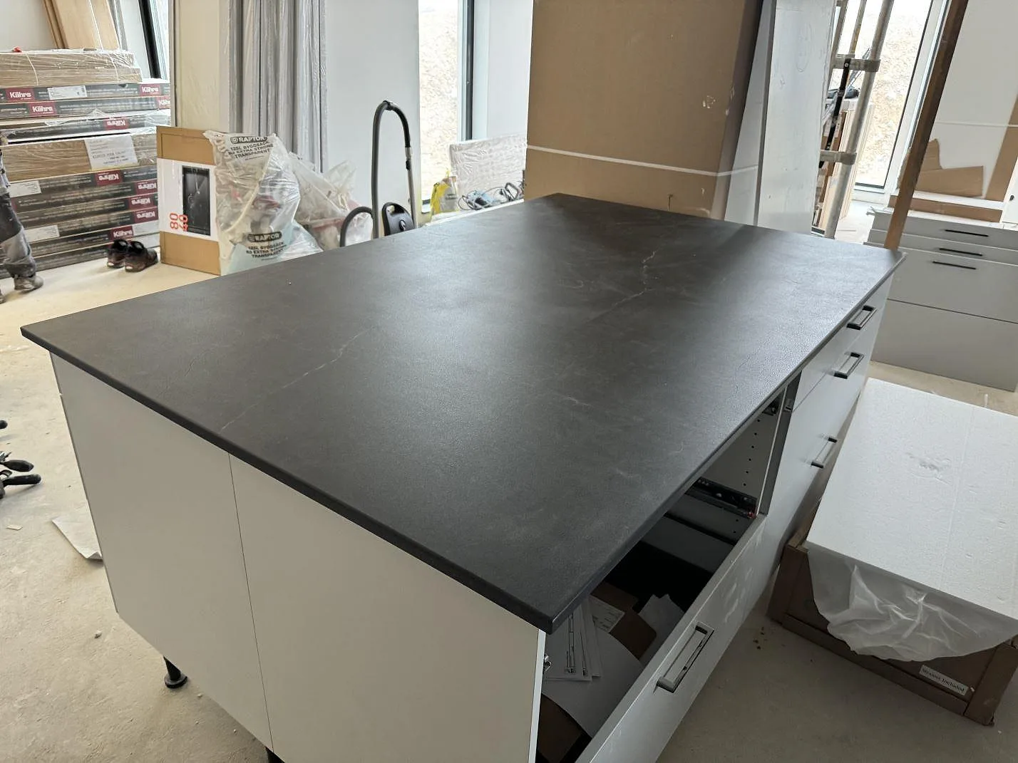 Stor köksö i matt Dekton Laos med kolgrå yta och diskreta ljusa ådror i ett kök i Halmstad.