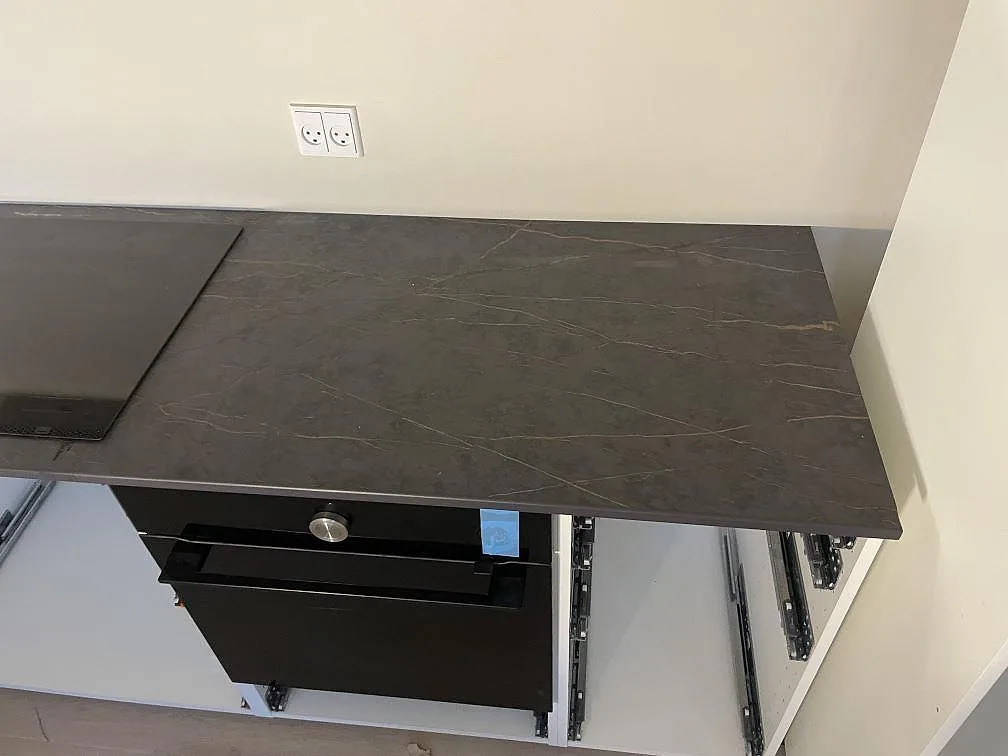 Närbild på den matta mörka Dekton Laurent där guldådringen löper över bänkskivan, kök under montering i København S.