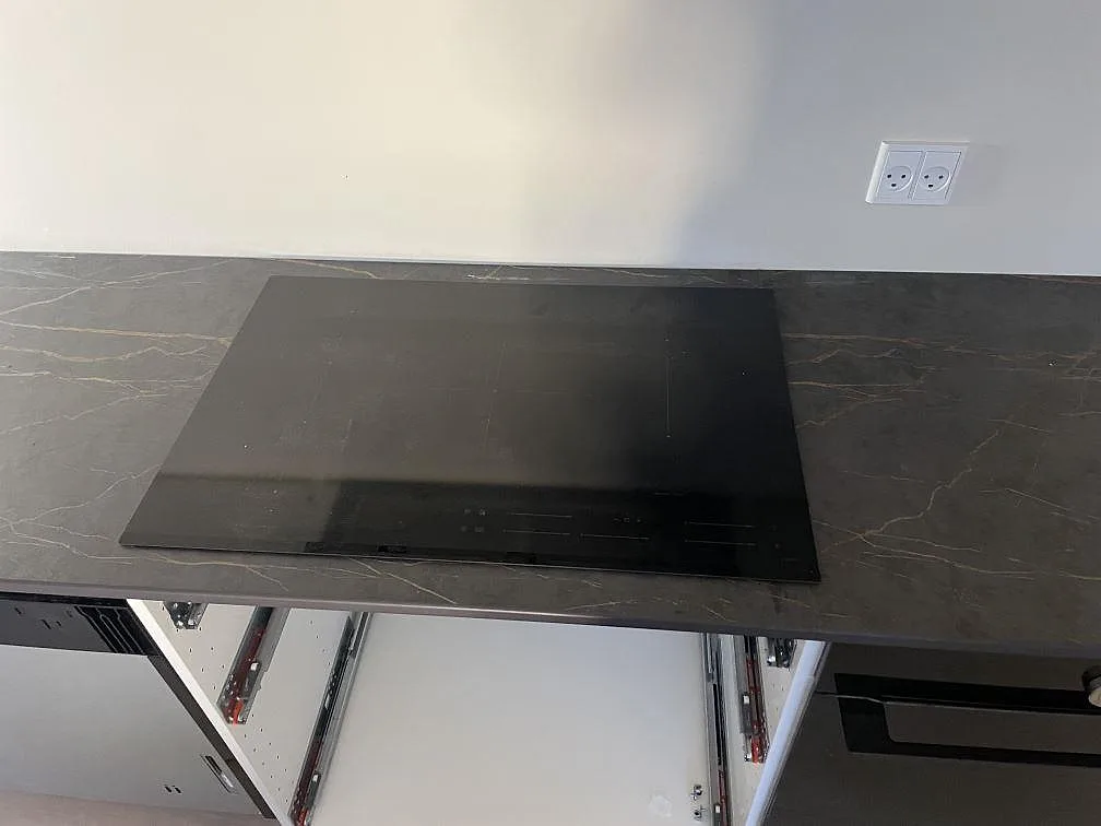 Infälld induktionshäll i matt mörk Dekton Laurent med guldådrigt mönster, köksbänkskiva i København S.