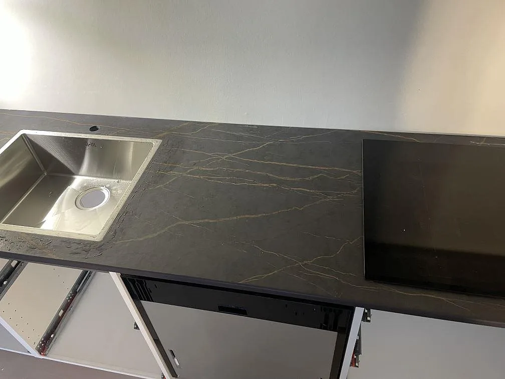 Bänkrad i Dekton Laurent med underlimmad rostfri diskho och infälld induktionshäll, matt mörk keramik med varma guldådror, kök i København S.