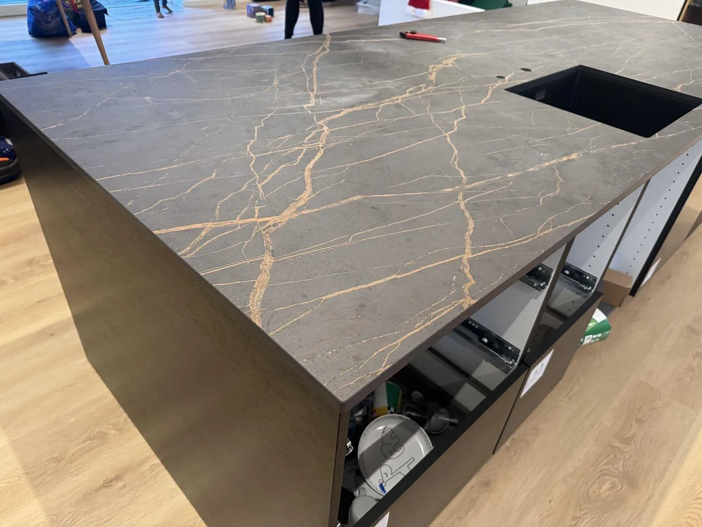 Närbild av köksö i matt Dekton Laurent med rektangulärt urtag och markerad guldådring i ett kök i Odense SV.
