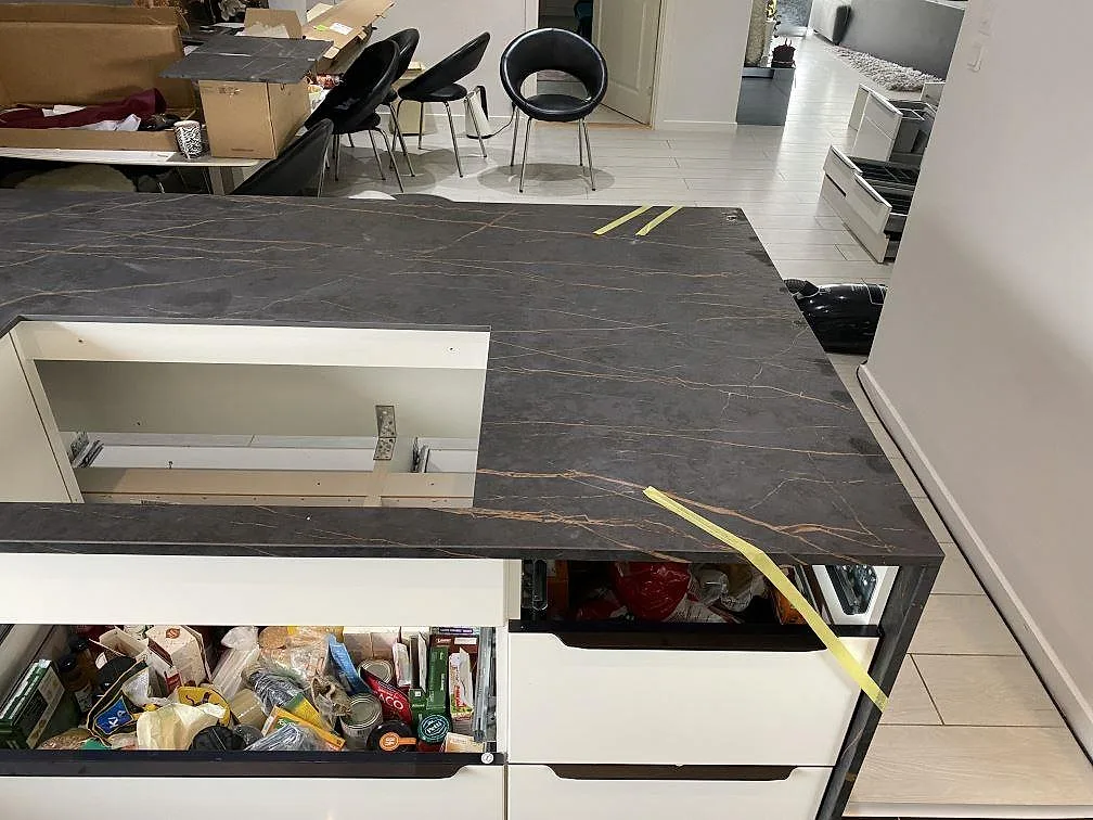 Bänkskiva i Dekton Laurent kring öppna stommar i ett kök under montering, mörk matt keramik med tydlig guldådring i Vallensbæk.