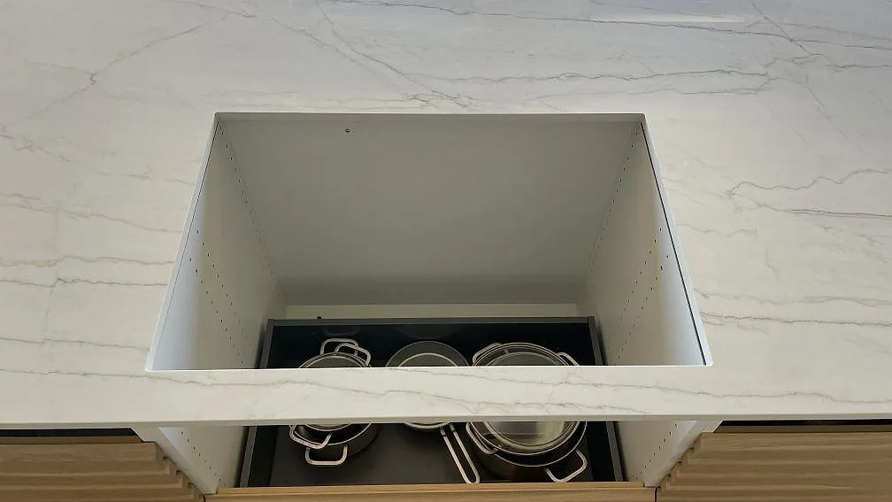 Polerad Dekton Limbo köksö i keramik med rektangulär öppning och ljus ådring under montering i Bunkeflostrand.