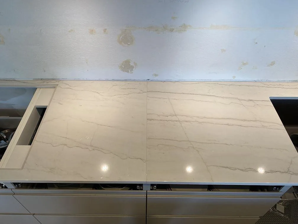 Detalj av ljus Dekton Limbo bänkskiva med rektangulära utskärningar och polerad ådrad yta i København s.