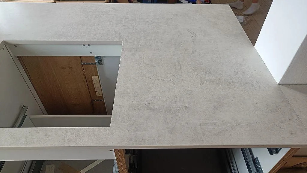 Topvy över matt Dekton Lunar på kökshalvö med stor öppning och synlig struktur i stenyta i København Ø.