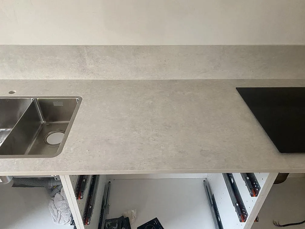 Bänkskiva i matt Dekton Lunar ovanifrån med underlimmad dubbel rostfri diskho och infälld induktionshäll i Sävedalen.