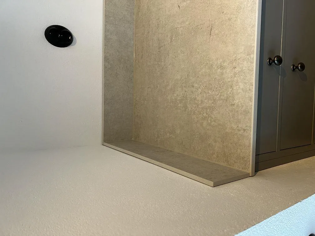 Dekton Lunar bänkskiva och väggbeklädnad i matt ljusgrå keramik mot grå köksskåp i Tygelsjö, fotad under montering.