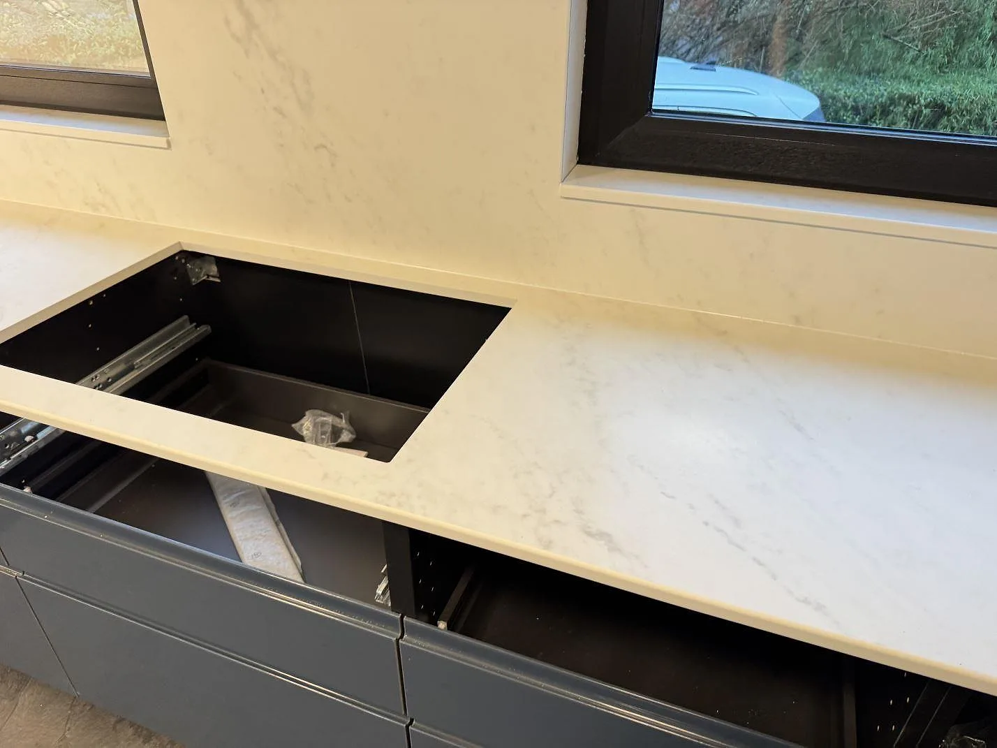 Matt köksbänkskiva i Dekton Marina Kc Velvet med rektangulärt urtag och låg stänkkant under fönster i Lund.