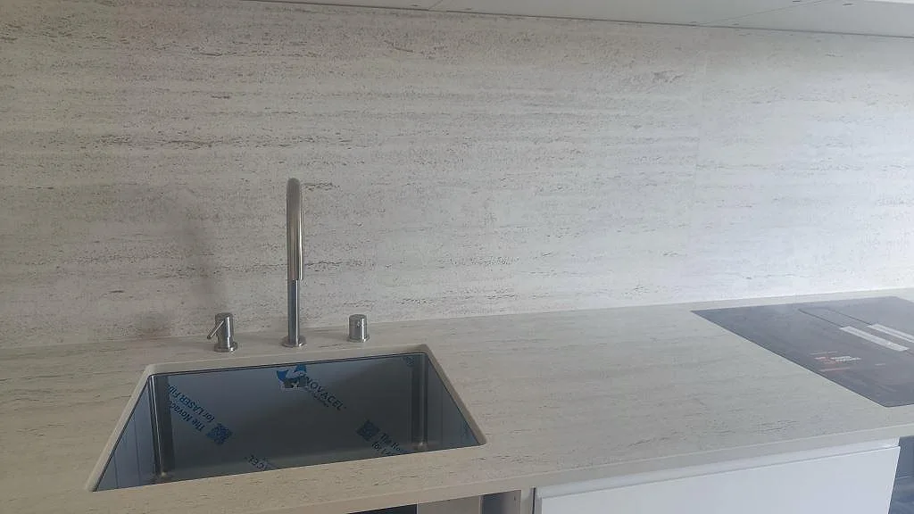 Matt Dekton Marmorio bänkskiva med mörk diskho, svart häll och högt stänkskydd i ett kök i Halmstad.