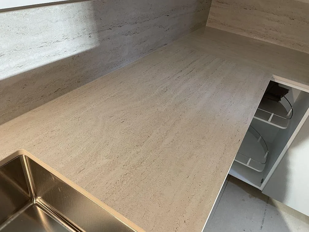 Köksbänkskiva i matt Dekton Marmorio med ljus ådring, rostfri diskho och L-format hörn i ett kök i Malmö.