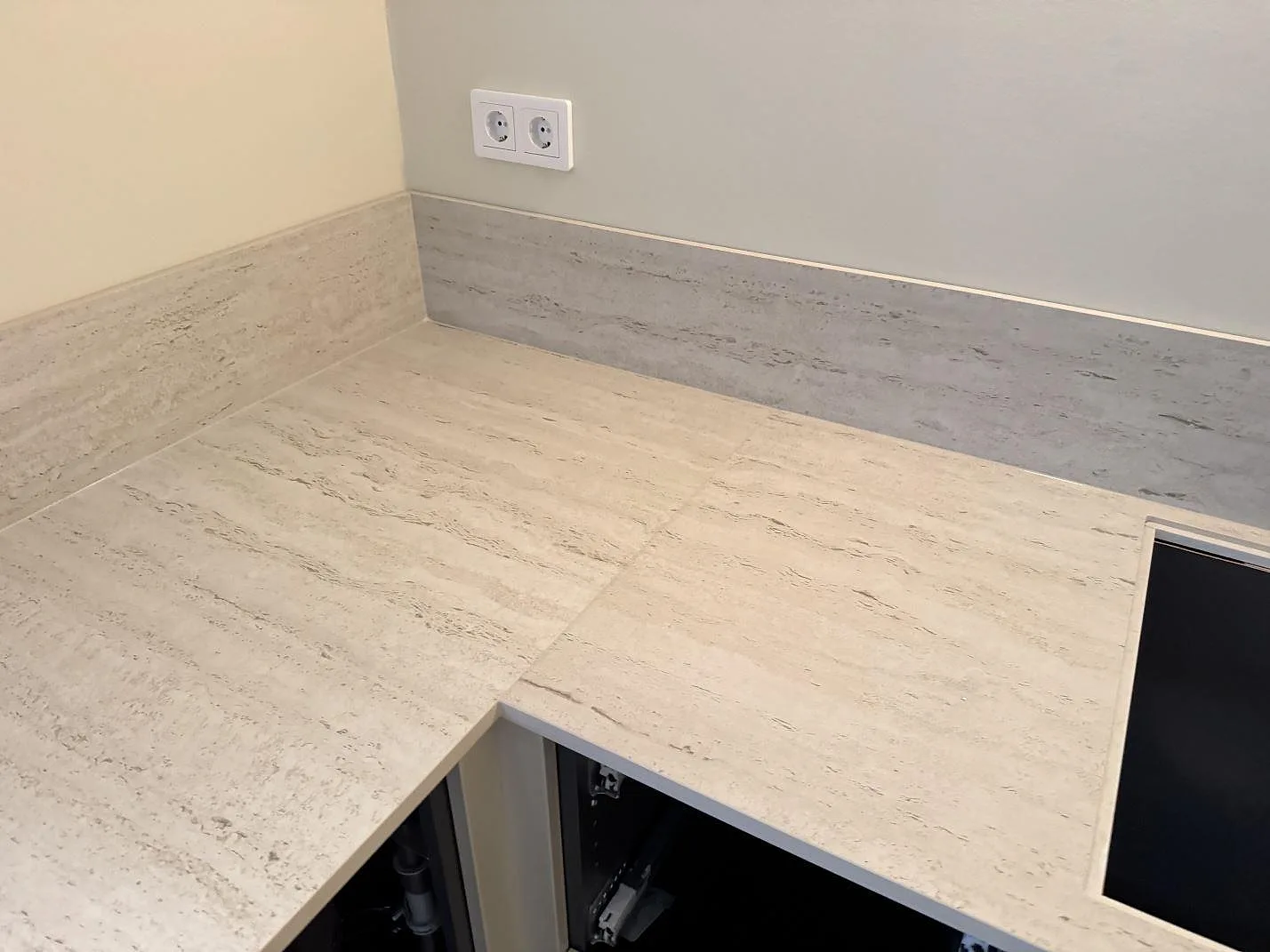 Köksbänkskiva i matt Dekton Marmorio, keramik, med låg stänkkant och ljus ådring i ett kök i Rydebäck.