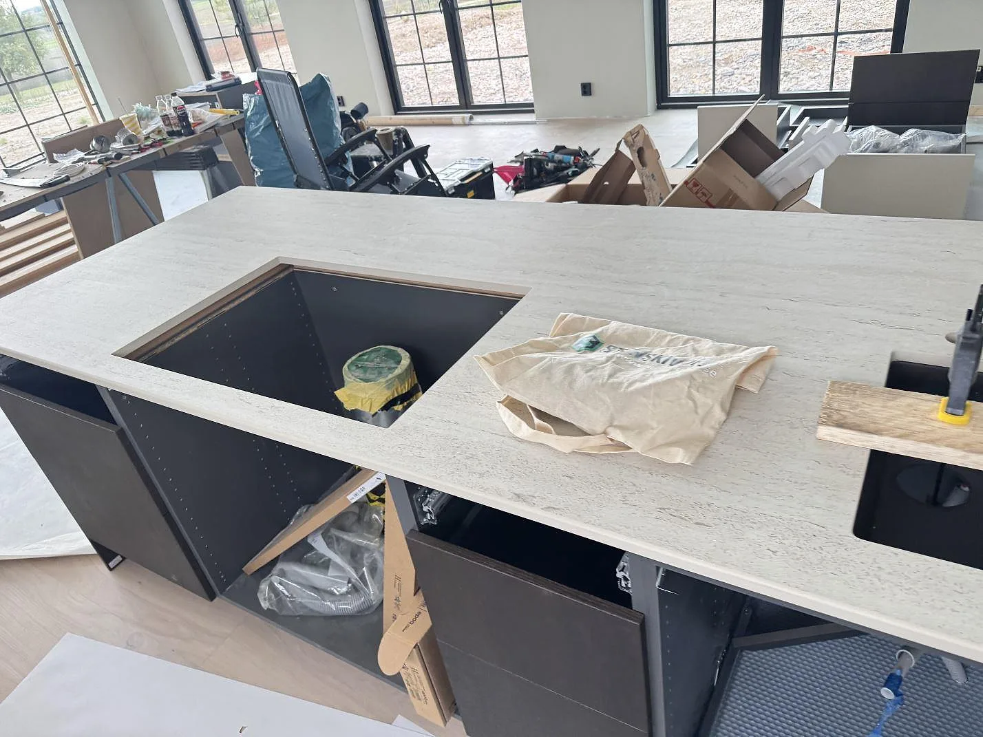 Detalj av köksö i matt Dekton Marmorio keramik med stort förberett urtag och monteringsverktyg i Skurup.